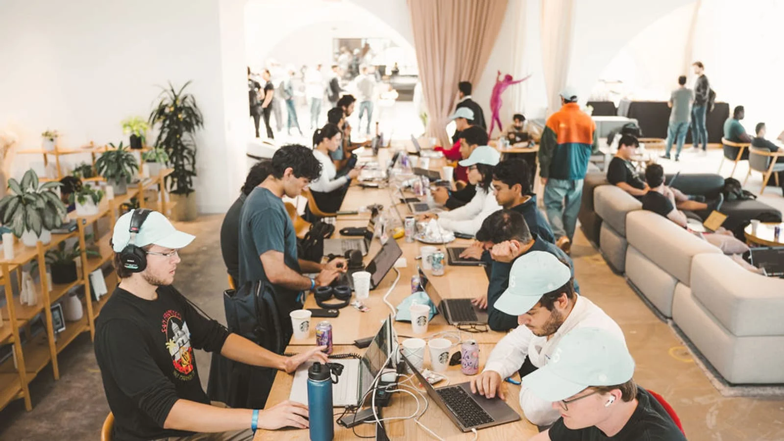 Daniel Joseph Mueller, foreground left, collaborating with participants around laptops at the 2022 OpenAI Environmental Hackathon