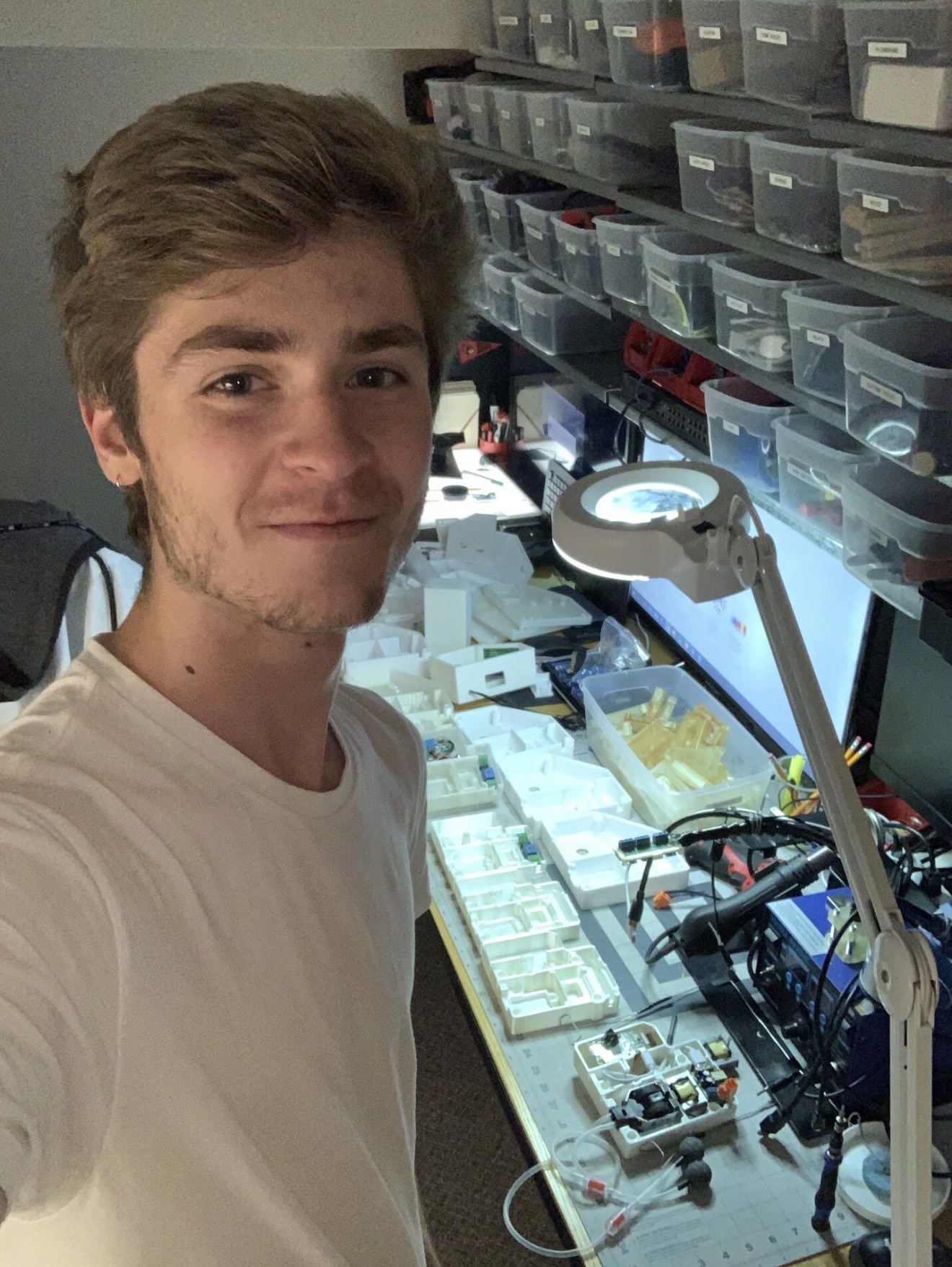 Younger Daniel Joseph Mueller at an electronics workbench with circuit boards and 3D-printed parts